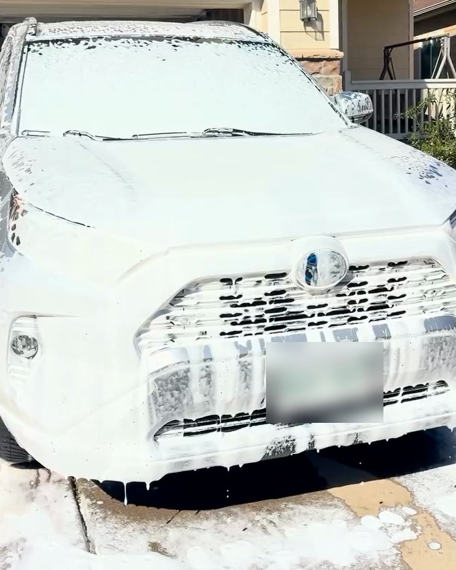 A Toyota RAV4 covered in foam in a driveway