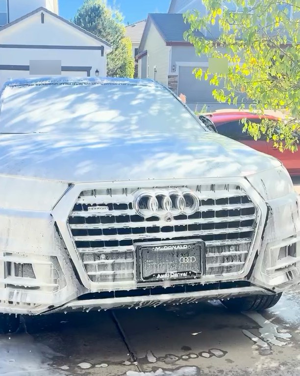 An Audi Q7 covered in foam in a driveway